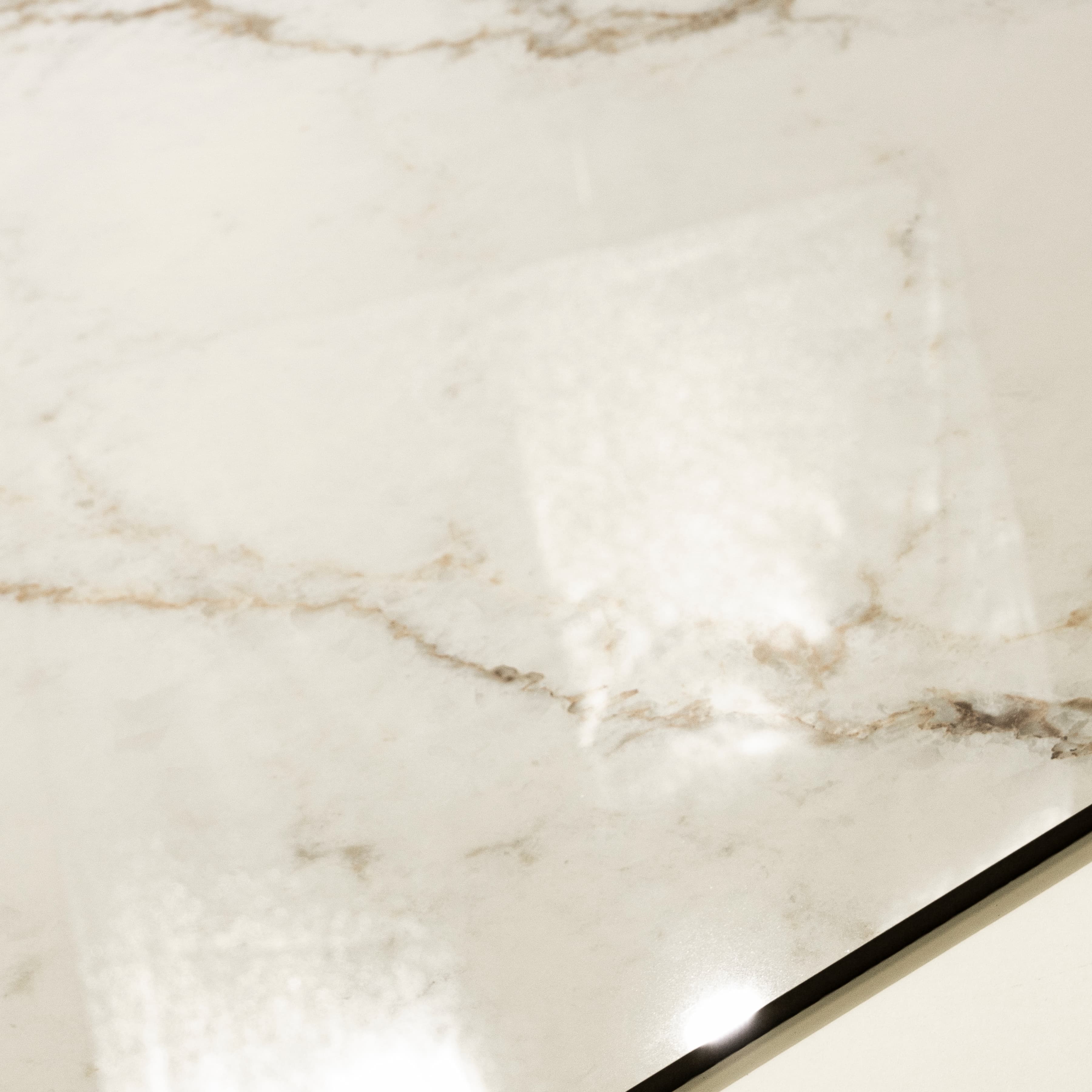 Close-up of Signora glossy porcelain tile showing mirror-polished marble surface with intricate gold vein clusters and 9mm thickness