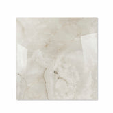 Marbella Gold glossy porcelain tile 120x120cm displayed on easel against luxury marble backdrop for UAE interior design