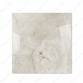 Marbella Gold glossy porcelain tile 120x120cm displayed on easel against luxury marble backdrop for UAE interior design