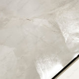 Close-up of Marbella Gold glossy porcelain tile showing mirror-polished cream onyx surface with detailed gold vein detail and 9mm thickness