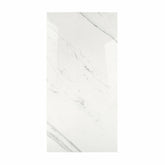 Statuario Platina BM porcelain slab displayed on easel against luxury backdrop showing crisp white marble surface with elegant grey veining for UAE interior design