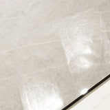 Close-up of Pietra Bianco glossy porcelain tile showing mirror-polished ivory stone surface with fine natural vein detail and 9mm thickness