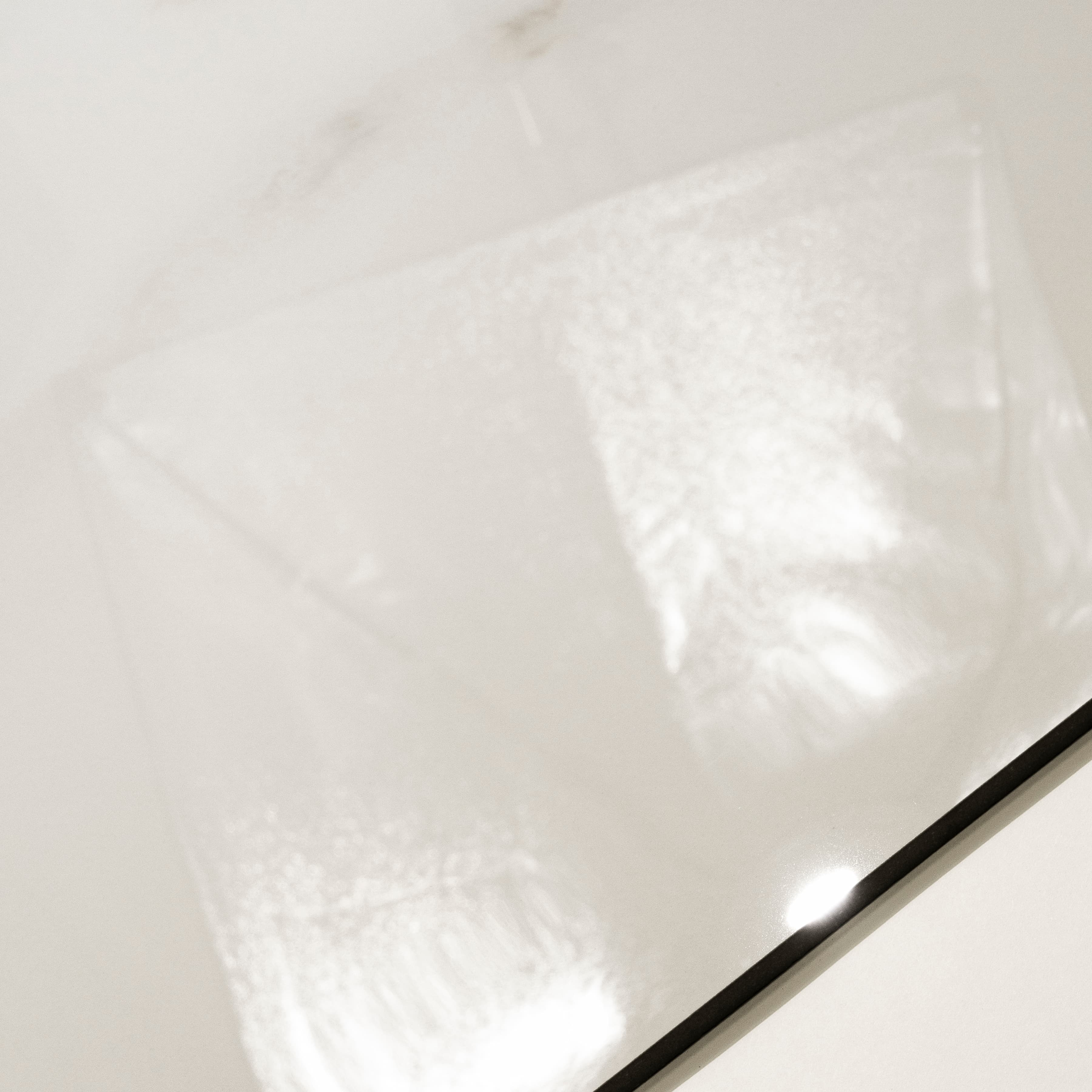 Close-up of Cecelia Gold glossy porcelain tile showing mirror-polished ivory marble surface with delicate golden vein detail and 9mm thickness