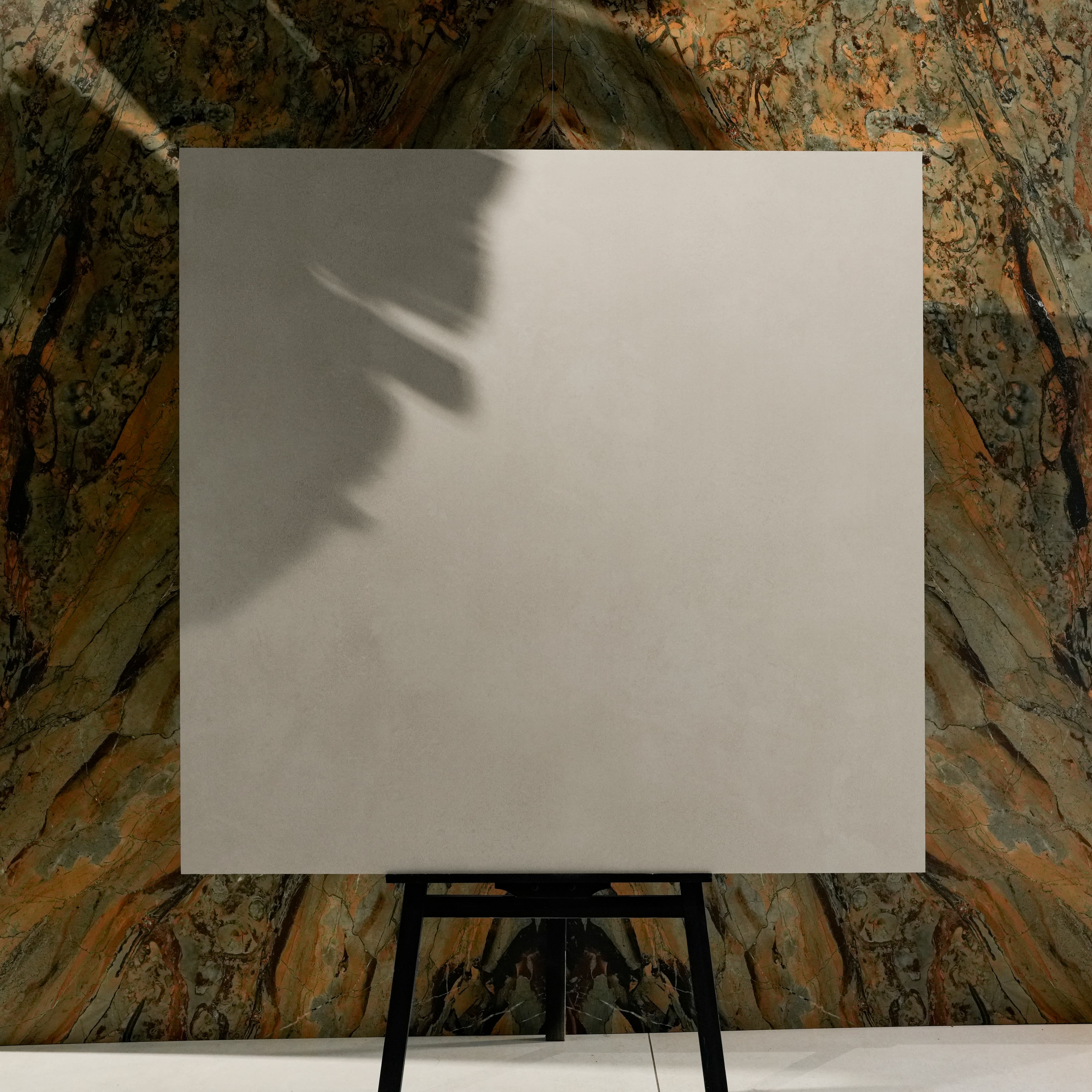 Meera Grey matte porcelain tile 120x120cm displayed on easel against luxury marble backdrop for UAE interior design