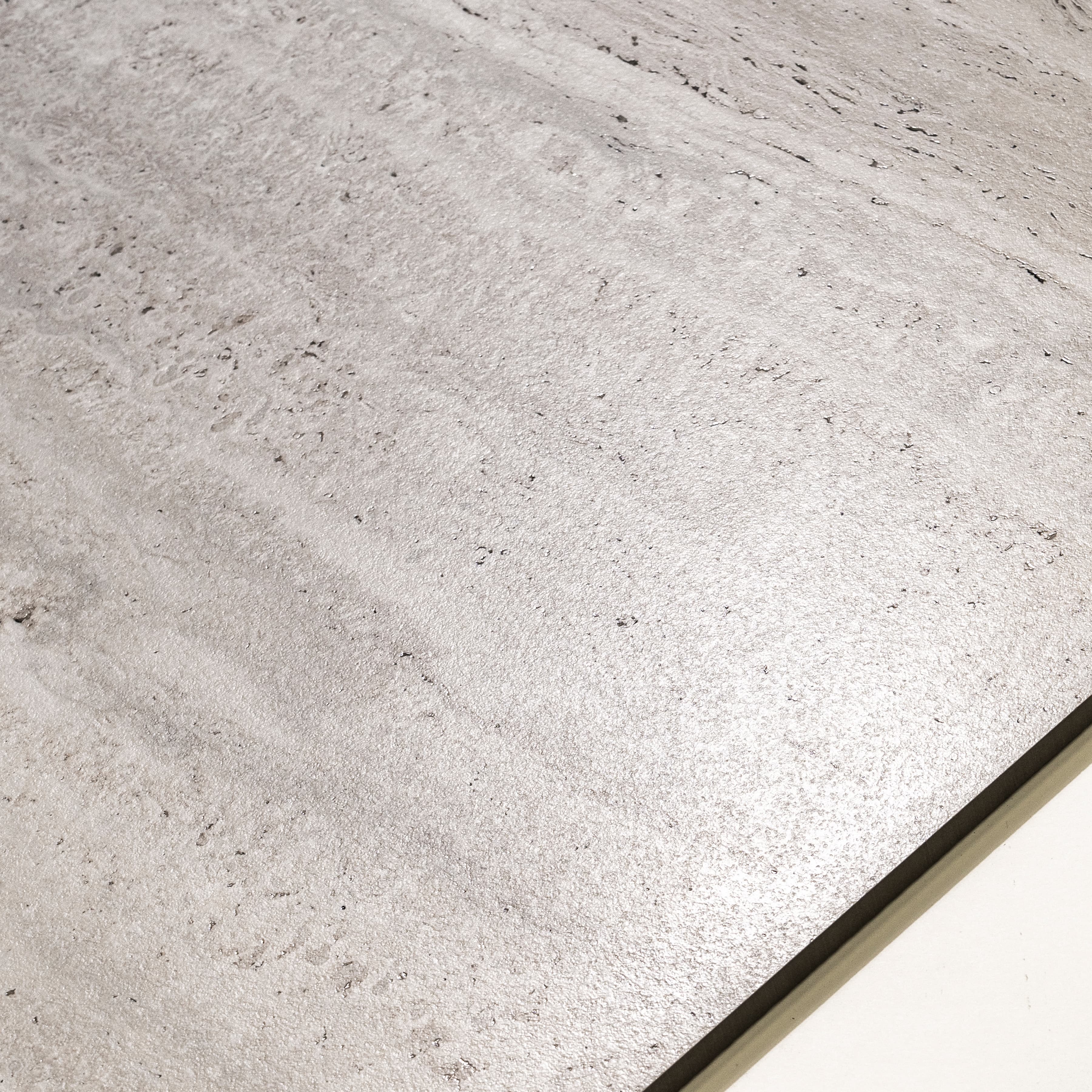 Roma Travertino Bianco large format porcelain tile angled view highlighting matte travertine finish, linear veining, and rectified edges