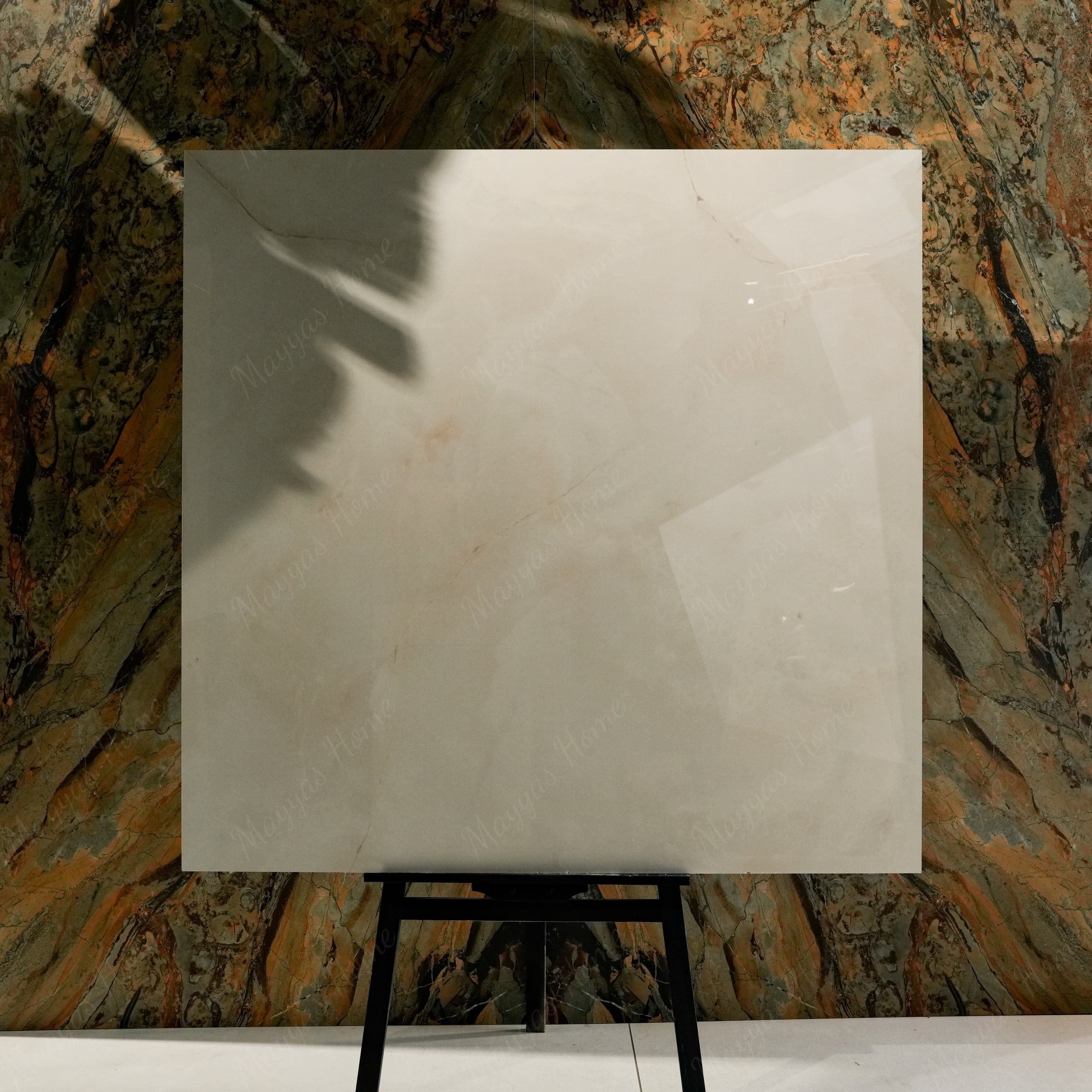 Crema Onyx glossy porcelain tile 120x120cm on easel against luxury marble backdrop showing cream and gold veining for UAE interiors