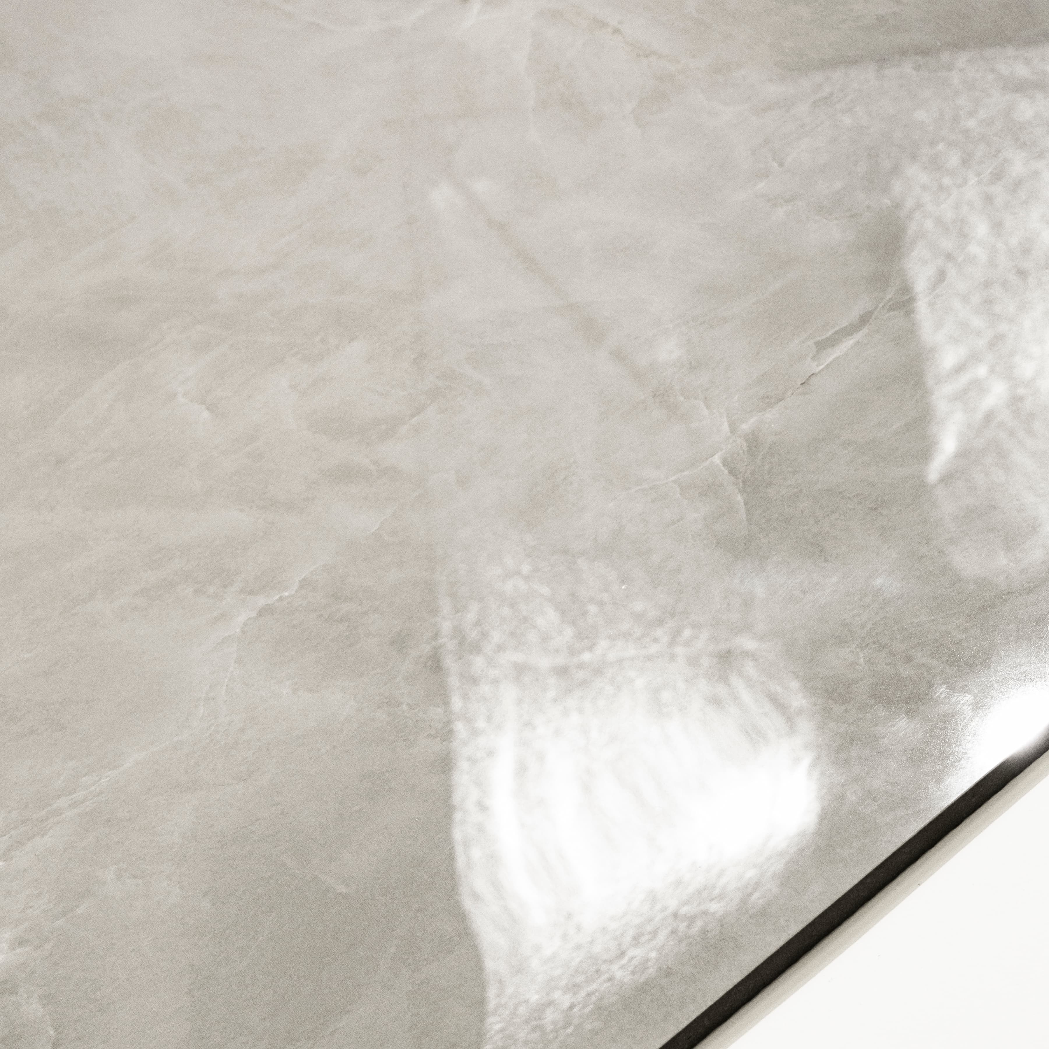Close-up of Royal Beige glossy porcelain tile showing mirror-polished marble surface with delicate white vein detail and 9mm thickness
